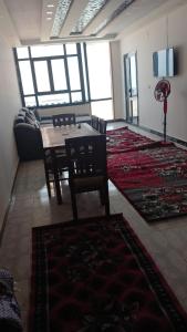 sala de estar con mesa, sillas y alfombras en الاسكندريه العجمي/اكتوبر شاطئ النخيل, en Alejandría