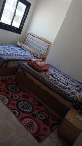 1 dormitorio con 2 camas individuales y alfombra en الاسكندريه العجمي/اكتوبر شاطئ النخيل, en Alejandría