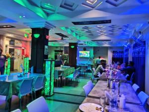 une salle à manger avec des tables, des chaises et des lumières dans l'établissement Hotel Ellora Cooch Behar, à Kuch Bihār