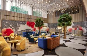 a lobby with blue chairs and tables and trees at Hyatt Centric Sector17 Chandigarh in Chandīgarh