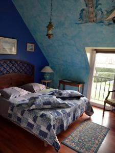 Schlafzimmer mit einem Bett mit blauer Wand in der Unterkunft B AND B Chambres d'Hôtes Les Falaises in Saint-Léonard