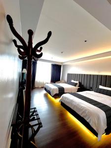Cette chambre d'hôtel dispose de 2 lits et d'une lumière au milieu. dans l'établissement The Forest Lodge at Camp John Hay privately owned unit with parking 545, à Baguio