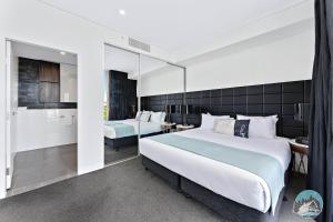 a bedroom with a large bed and a bathroom at 2 beds luxury apartment in the heart of chatswood12 in Sydney