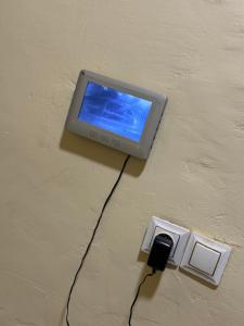 an electronic device with a blue screen on a wall at Prestige House in Ouagadougou