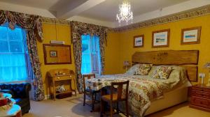 a bedroom with a bed and a table and chairs at Priskilly Forest Country House in Fishguard