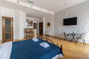1 Schlafzimmer mit einem blauen und weißen Bett und einer Küche in der Unterkunft Rynok Square apartment with balcony in Lwiw