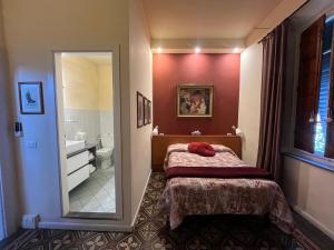 - une chambre avec un lit et un miroir ainsi qu'une salle de bains dans l'établissement Villa San Donato B&B, à Lucques