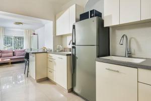 a kitchen with a refrigerator and a sink in it at Modern Living in Kings Courtyard in Jerusalem