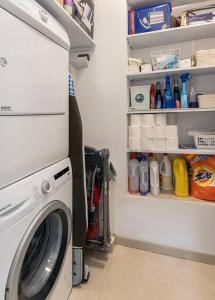 a laundry room with a washing machine and shelves at Modern Living in Kings Courtyard in Jerusalem