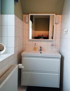 ein Bad mit einem Waschbecken und einem Spiegel in der Unterkunft Ferienwohnung Adriane in Nordhorn
