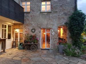 uma casa de tijolos com uma porta da frente e uma mesa com flores em Ehemalige Klosterschmiede -Wirtschaftswunder- em Ochsenhausen
