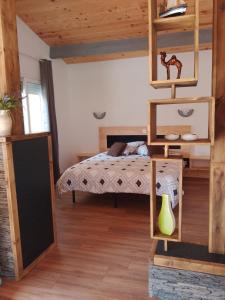 ein Schlafzimmer mit einem Bett in einem Zimmer mit Holzdecken in der Unterkunft Casa Chélo in Saint-Vincent-de-Tyrosse