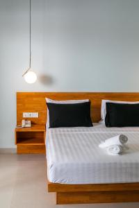 a bedroom with a large bed with a wooden headboard at Coco & Pineapple Pants Hostel - CANGGU, BALI in Canggu