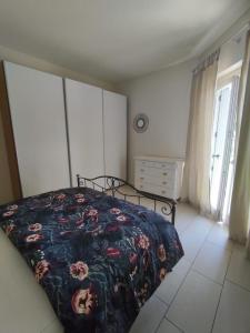 - une chambre dotée d'un lit avec un couvre-lit floral dans l'établissement Bilocale Lago di Garda, à Peschiera del Garda