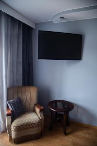 Camera con sedia e TV a schermo piatto di Apartament Rynek 10 a Ostrowiec Świętokrzyski