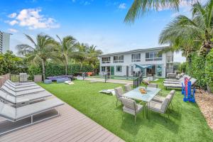 a backyard with a table and chairs and a house at Suite by Beach Waterfront Lago Key Three in Fort Lauderdale