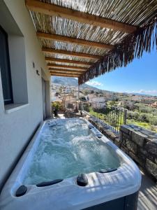 a hot tub on the balcony of a house at Petrichor in Kalamata