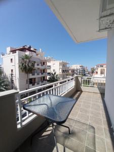 a balcony with a table and a view of a city at Tasos Seagull apartments in Chania