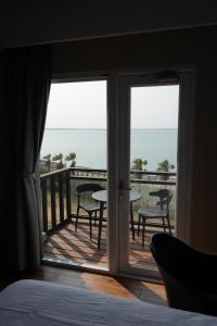 1 dormitorio con vistas al océano desde el balcón en Jia Xiang Lin Guan Hai Homestay 2, en Magong