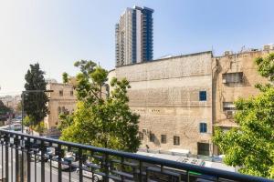 - un balcon offrant une vue sur un immeuble avec un gratte-ciel dans l'établissement Yefeh Nof - City Center 2BR Apartment, à Jérusalem