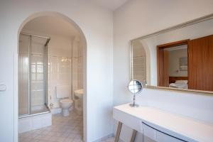 a bathroom with a toilet and a mirror at Lieblingsplatz Hotel Seedeich in Grömitz
