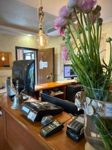 un escritorio de oficina con un jarrón de flores. en Euro House Inn Airport, en Fiumicino