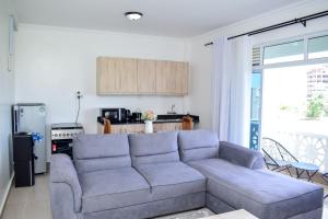 a living room with a couch and a kitchen at Siloam Apartments in Mombasa