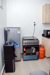 a kitchen with a stove and a refrigerator at Siloam Apartments in Mombasa