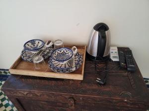 uma mesa com uma bandeja com pratos e copos em Youssef em Fez