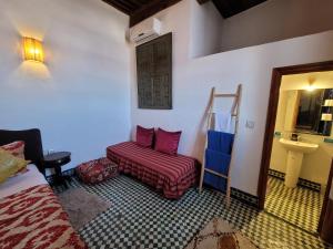 um quarto com uma cama, uma cadeira e um lavatório em Youssef em Fez
