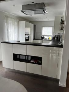 a kitchen with white cabinets and a black counter top at HausGregor, Messe 15 min, City 20 min und Erholung im Grünen in Winkelhaid