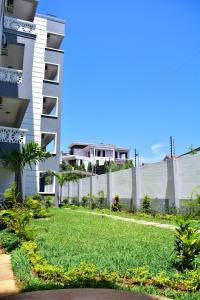 a yard in front of a building with a fence at Siloam Apartments in Mombasa