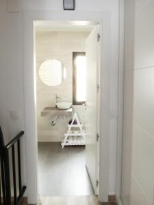 Baño blanco con lavabo y espejo en VUT Adarve, en Ávila