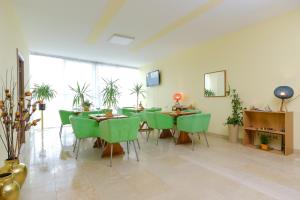 Primus Apartments في فيسوكو: غرفة طعام مع كراسي وطاولات خضراء