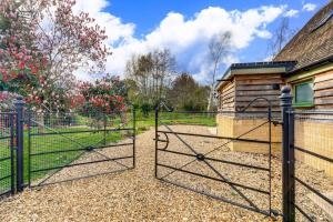 an open gate to a yard with a fence at Hiron's Piece and Honeysuckle Cottage - Hot Tub Packages Available in Weston Subedge