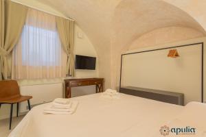 a bedroom with a bed and a chair and a television at Zema Home by Apulia Accommodation in Bari