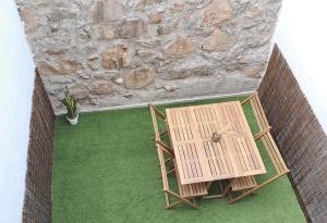 una vista aérea de una mesa y sillas frente a una pared de piedra en VUT Adarve en Avila