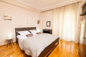 sypialnia z dużym łóżkiem i oknem w obiekcie Four Reasons Apts Ntepo w Salonikach