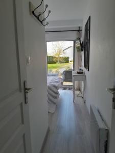 einen Flur mit einer Tür zu einem Zimmer mit einem Tisch in der Unterkunft Chez Maryline in Chalonnes-sur-Loire