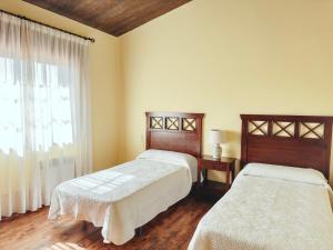 een slaapkamer met 2 bedden en een raam bij ThatsHome Villa Pedriñas in Sanxenxo