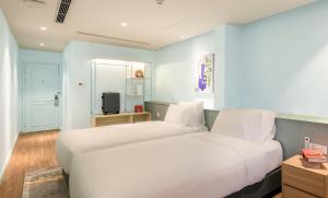 ハノイにあるM Village Hotel Hồ Gươmのベッドルーム1室(白いベッド2台、青い壁付) +13枚の写真
