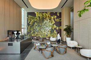a lobby with tables and chairs and a flower wall at COMO Metropolitan Singapore in Singapore