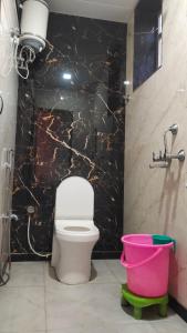uma casa de banho com WC e uma parede de mármore preto em Hotel khatushyamji palace em Khātu
