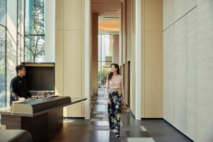 a woman walking down a hallway with a man at COMO Metropolitan Singapore in Singapore +122 photos