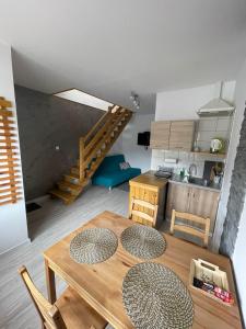 a kitchen with a wooden table and a kitchen with a staircase at Apartamenty Młynne in Muszyna