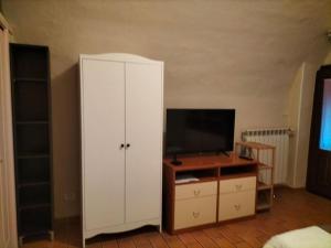 un soggiorno con armadio bianco e TV di Tranquillità in corte con giardino vicino a Brescia a Concesio