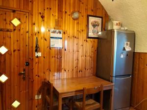 una cucina con frigorifero e parete in legno di Tranquillità in corte con giardino vicino a Brescia a Concesio