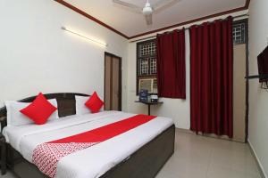 a bedroom with a large bed with red pillows at OYO Hotel Ocean View in New Delhi