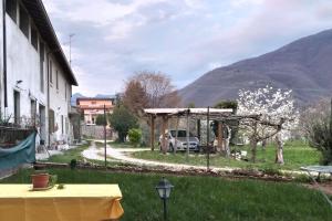 a table in the grass next to a building with a car at Intero Appartamento in Corte con giardino in Concesio