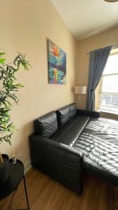 a black leather couch in a living room with a window at City Gem - Central & Stylish 1 Bed Apartment in Dublin